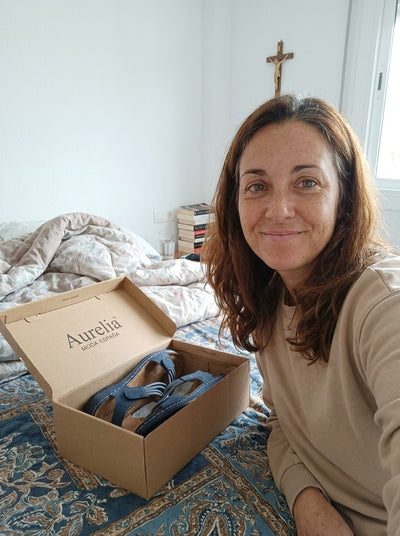 Clienta con la caja de sandalias ortopédicas Flex sobre la cama